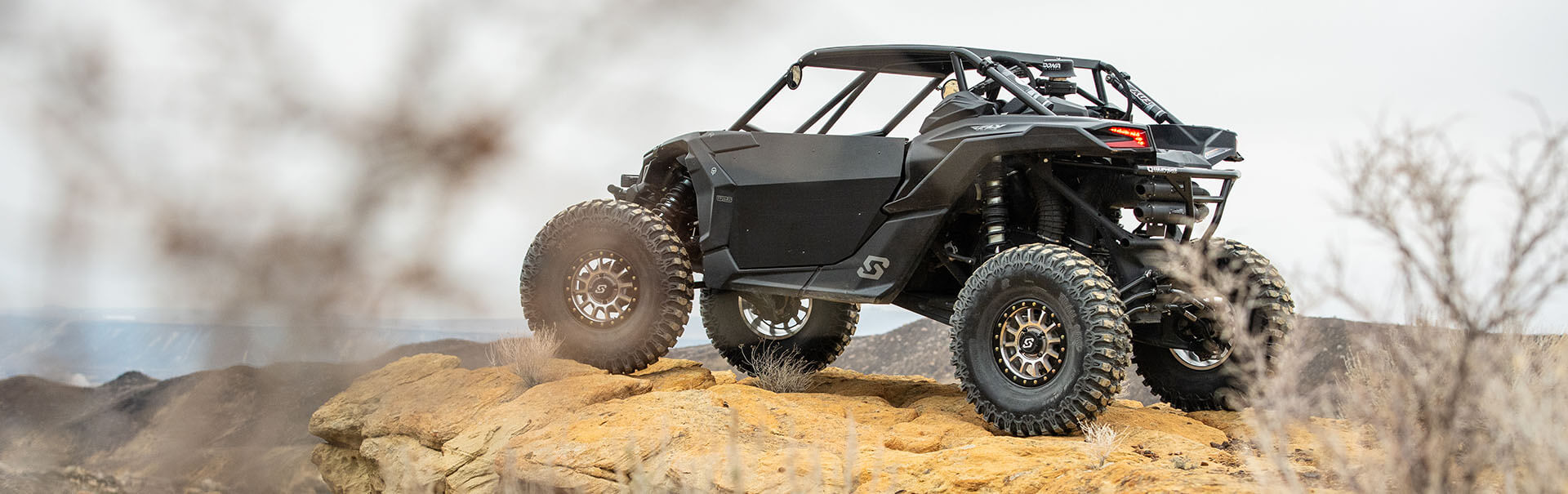 Black UTV side by side on cliff looking out into the valley below