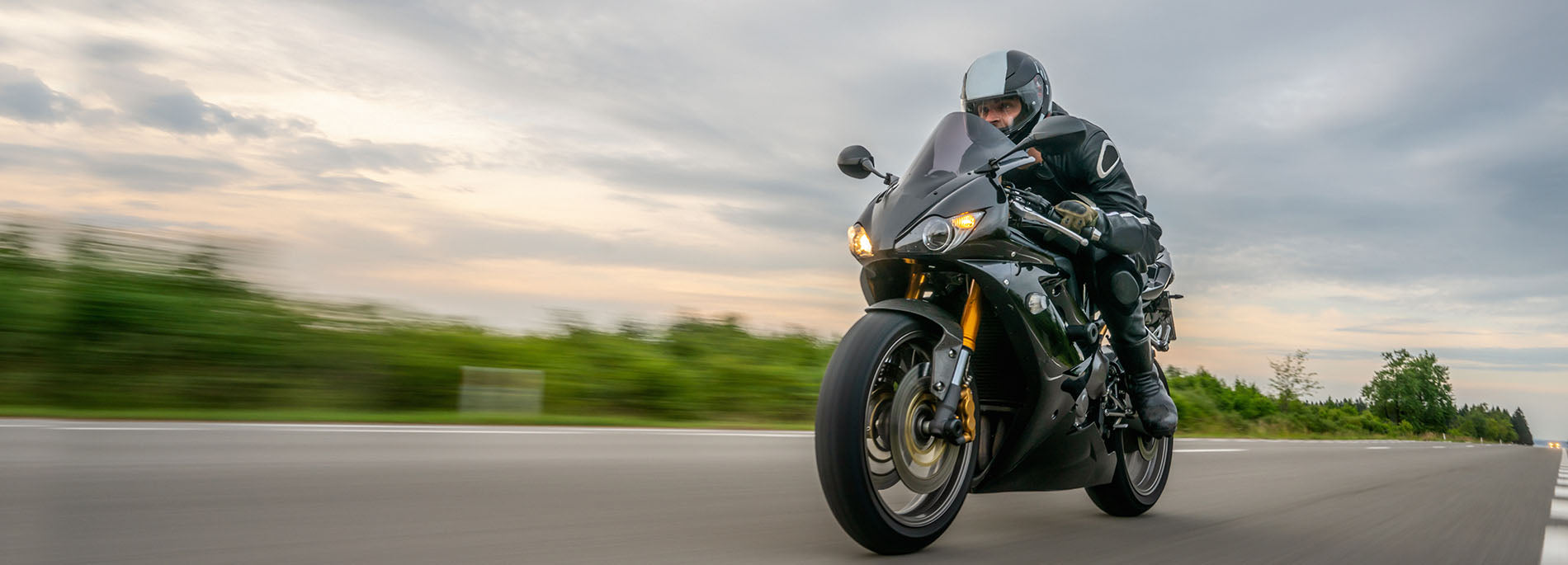 Black sport bike racing down road with scenery blurred