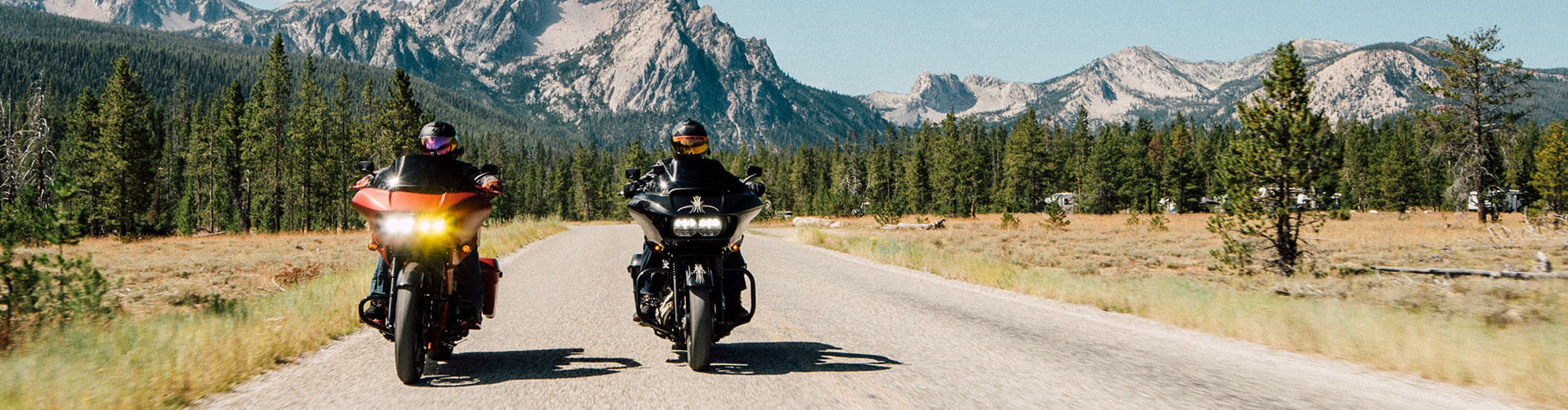 Two Harley-Davidson Road Glides riding down the road in front of mountains